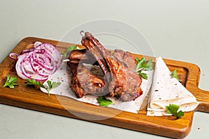 Grilled lamb ribs with herbs and spices on a wooden board