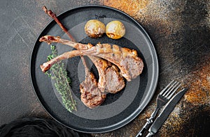 Grilled lamb ribs loin, on plate, on old dark rustic background, top view flat lay , with copyspace  and space for text