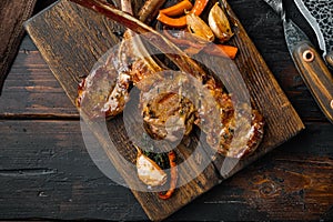 Grilled lamb ribs loin, on wooden serving board, on old dark  wooden table background, top view flat lay , with copyspace  and