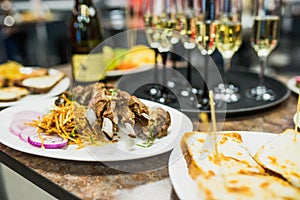 Grilled lamb ribs on a white plate with a side dish