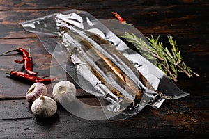 Grilled lamprey vacuum pack, on old dark  wooden table background