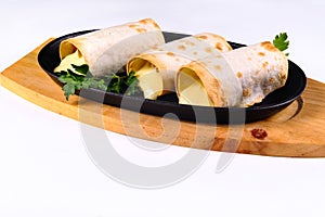 Grilled lavash rolls with suluguni cheese, picnic lunch, appetizer, delicious dish in a frying pan on a white isolated