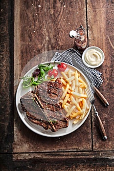 Grilled lean T-bone steak with golden potato chips