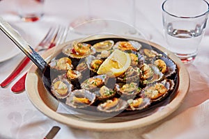 Grilled limpets served with lemon - traditional seafood on Madeira island, Portugal