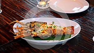 Grilled Lobster Meal with Herbs and Baked Cheese on Dinner Plate