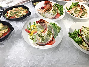 Grilled lobsters, stewed prawns and shrimps with pesto souse and vegetables