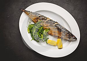 Grilled mackerel fillets with lemon on black board photo