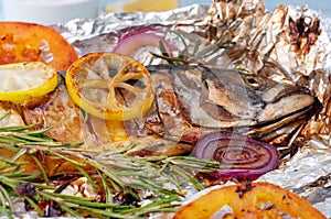 Grilled mackerel fish in foil with vegetables