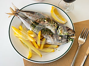 Grilled mackerel fish with french fries and lemon