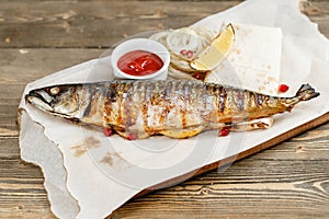 Grilled mackerel. Serving on a wooden Board on a rustic table. Barbecue restaurant menu, a series of photos of different