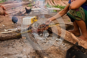 grilled meat at a camfire in a traditional village near luang namtha