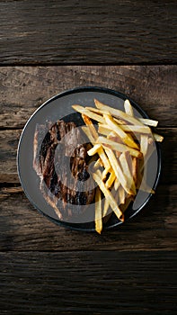 Grilled meat and fries presented enticingly on a wooden table