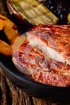 Grilled meat with grilled vegetables on a wooden table