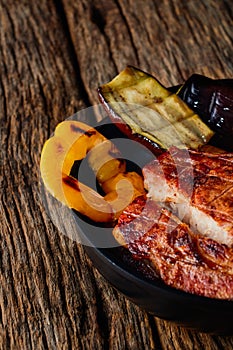 Grilled meat with grilled vegetables on a wooden table