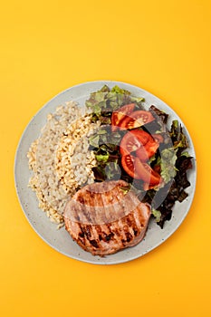 grilled meat hamburger with boiled rice and salad on white dish