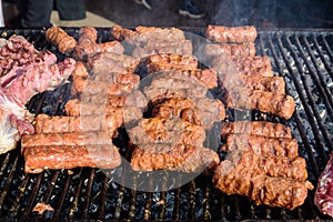 Grilled meat rolls called Mici or Mititei, traditional fresh Romanian barbeque grill food cooked on the barbeque at a street food