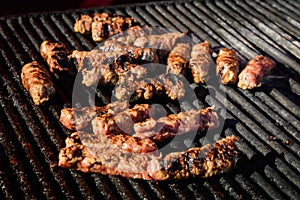 Grilled meat rolls called Mici or Mititei, traditional fresh Romanian barbeque grill food cooked on the barbeque at a street food