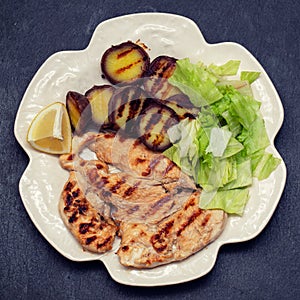 Grilled meat with salad and sweet potato on white beautiful dish