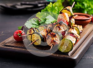 Grilled meat skewers, chicken shish kebab with zucchini, tomatoes and red onions.