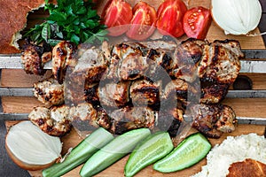 Grilled meat skewers, shish kebab, healthy vegetable fresh tomato, cucumber, onion and bread, top view