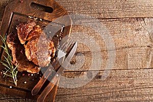 Grilled meat with spices on a wooden kitchen board