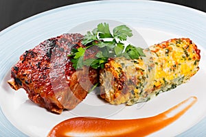 Grilled meat steak with grilled corn in cheese and greens in plate on dark wooden background. Hot Meat Dishes.