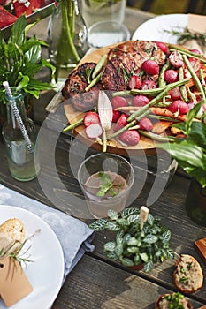 Grilled meat with vegetables served on the round wooden coaster