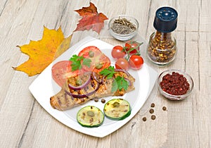 Grilled meat with vegetables on a white plate. horizontal photo.