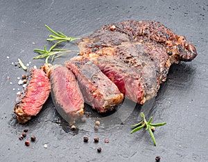 Grilled medium rare ribeye steak on gray stone plate