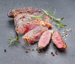 Grilled medium rare ribeye steak on gray stone plate