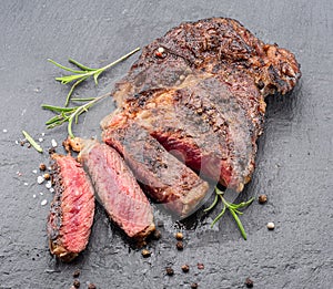 Grilled medium rare ribeye steak on gray stone plate