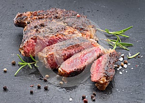 Grilled medium rare ribeye steak on gray stone plate
