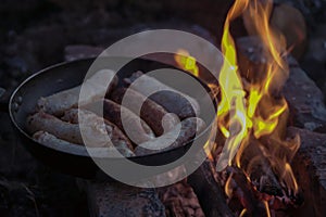 Grilled minced meat sausages, lie in a pan near the fire