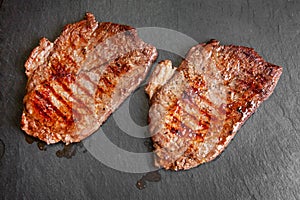 Grilled minute steak of marbled beef on a stone slate board, close up