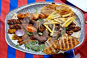 Grilled mixed meat with potatoes,Tomato, onion and breads.