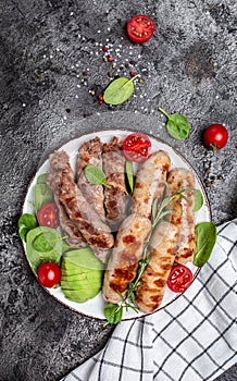 Grilled Munich Veal Sausages and meat rolls wrapped bacon, chevapchichi or Kofta kebab. Ketogenic diet, vertical image. top view.