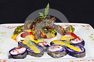 Grilled Octopus, gourmet dish from Peru. Served with purple potatoes (nativa)