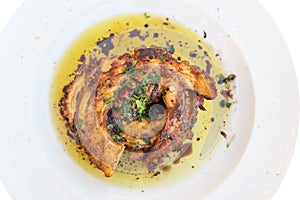 Grilled octopus with olive oil on a plate