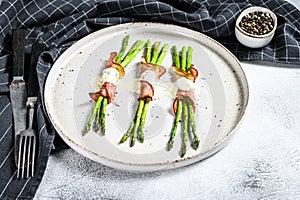 Grilled organic asparagus wrapped in pork bacon. Gray background. Top view