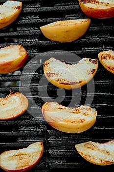 Grilled peach on black gas grill. Grilled dessert