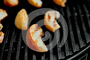Grilled peach on black gas grill. Grilled dessert