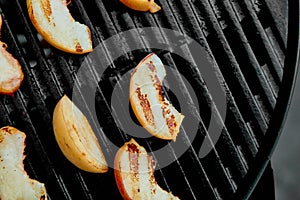 Grilled peach on black gas grill. Grilled dessert.