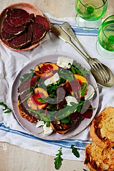 Grilled peaches, goat cheese, and bresaola salad