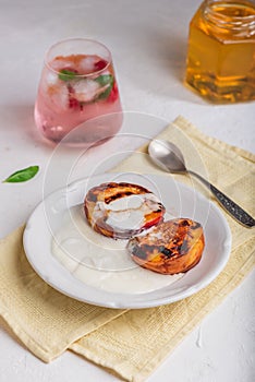 Grilled Peaches with Honey and Whipped Heavy Cream on White Plate