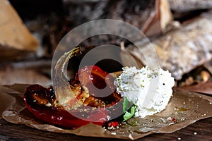 grilled peppers with mozzarella and tomato sauce on wooden table