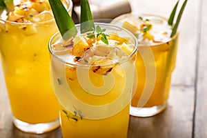 Grilled pineapple cocktail or mocktail garnished with pineapple leaves