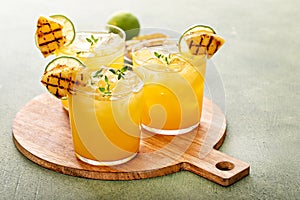 Grilled pineapple margarita garnished with a slice of pineapple and lime