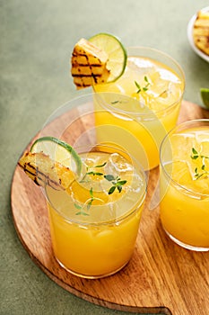 Grilled pineapple margarita garnished with a slice of pineapple and lime