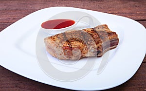 Grilled pork chop with Cranberry sauce on plate on wooden board