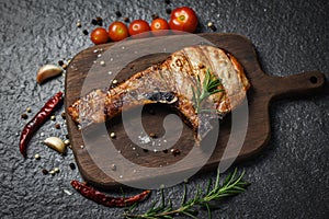 Grilled pork chop meat on black background - Pork chops steak with herb and spices serve on wooden board